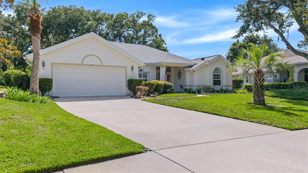 A single-story house with a white exterior, a two-car garage, and a concrete driveway — 52 SOUTHLAKE DRIVE, PALM COAST, FL