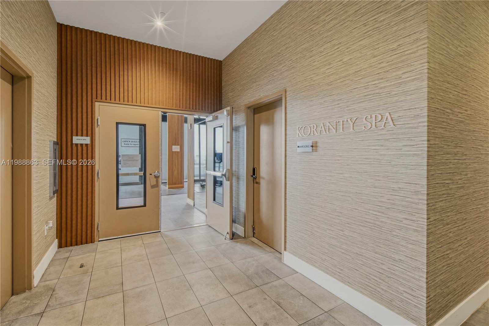 A hallway features a spa entrance, a gym door, and textured wall paneling — 239 SW 9th St # 802, Miami FL 33130, MIAMI, FL