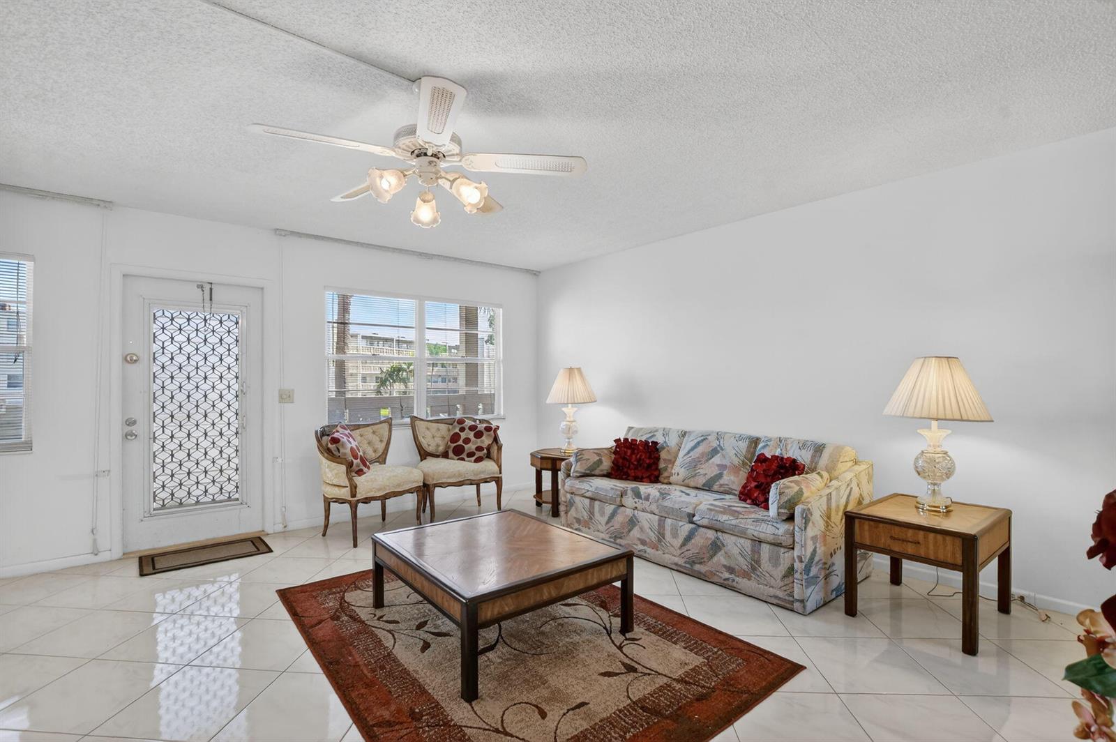 A living room features a patterned sofa, two accent chairs, a coffee table, and tile flooring — 2035 Ainslie, Boca Raton FL 33434, BOCA RATON, FL