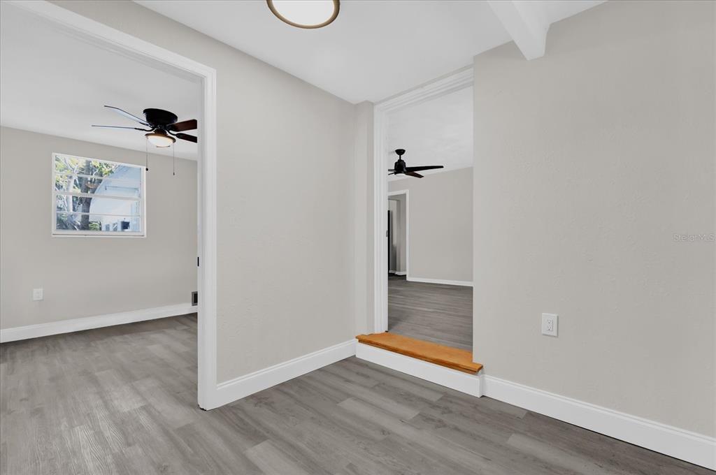 An interior view showing a room with gray flooring, white walls, and two arched doorways — 204 LOUIS STREET, LEESBURG, FL