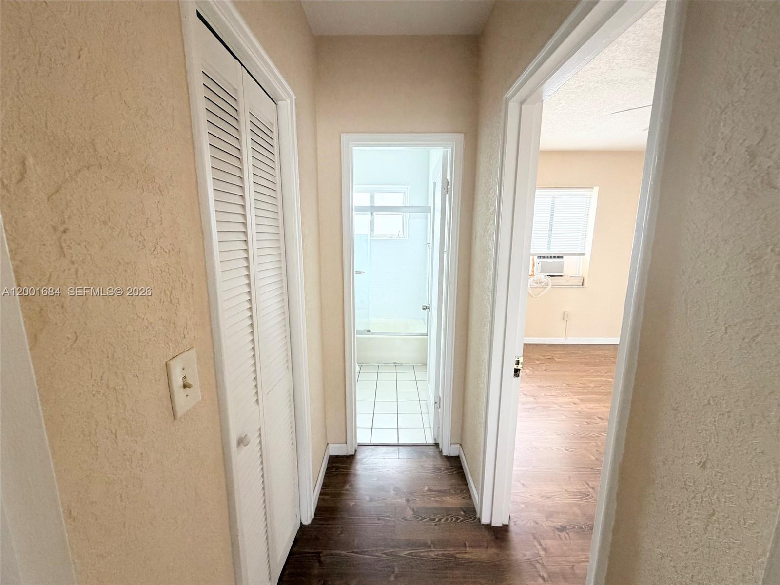 A hallway leads to a bathroom with a tub and an adjacent bedroom — 620 84th St # 25, Miami Beach FL 33141, MIAMI BEACH, FL