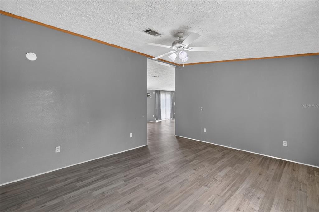 A living room with gray walls, wood-look flooring, and a white ceiling fan — 311 SE HIGHWAY 42, SUMMERFIELD, FL