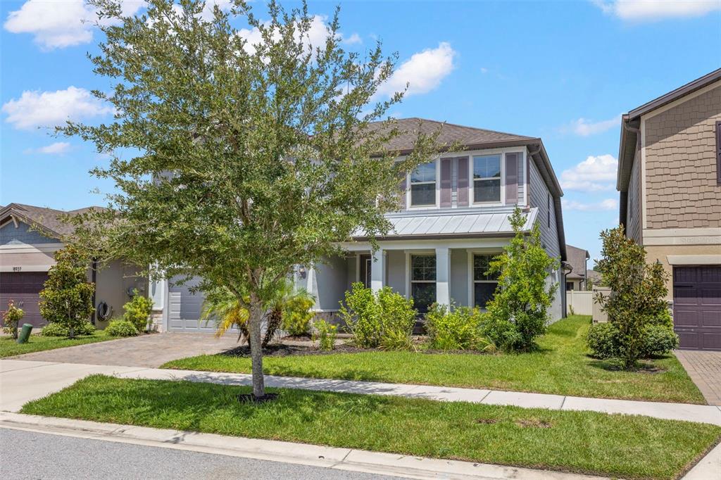 A two-story suburban house with a gray exterior, a front porch, and a paved driveway — 18935 BIRCHWOOD GROVES DRIVE, LUTZ, FL