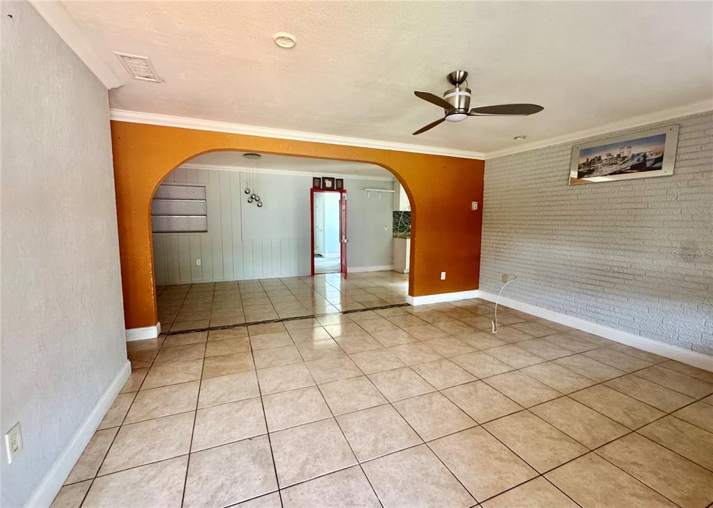 A living room with tile floors, an arched doorway, and a white brick wall — 2006 SARAZEN DRIVE, ORLANDO, FL
