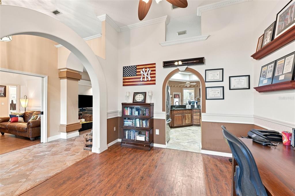 A home office with wood flooring, an arched doorway, and a wooden bookshelf — 18416 AUTUMN LAKE BOULEVARD, HUDSON, FL