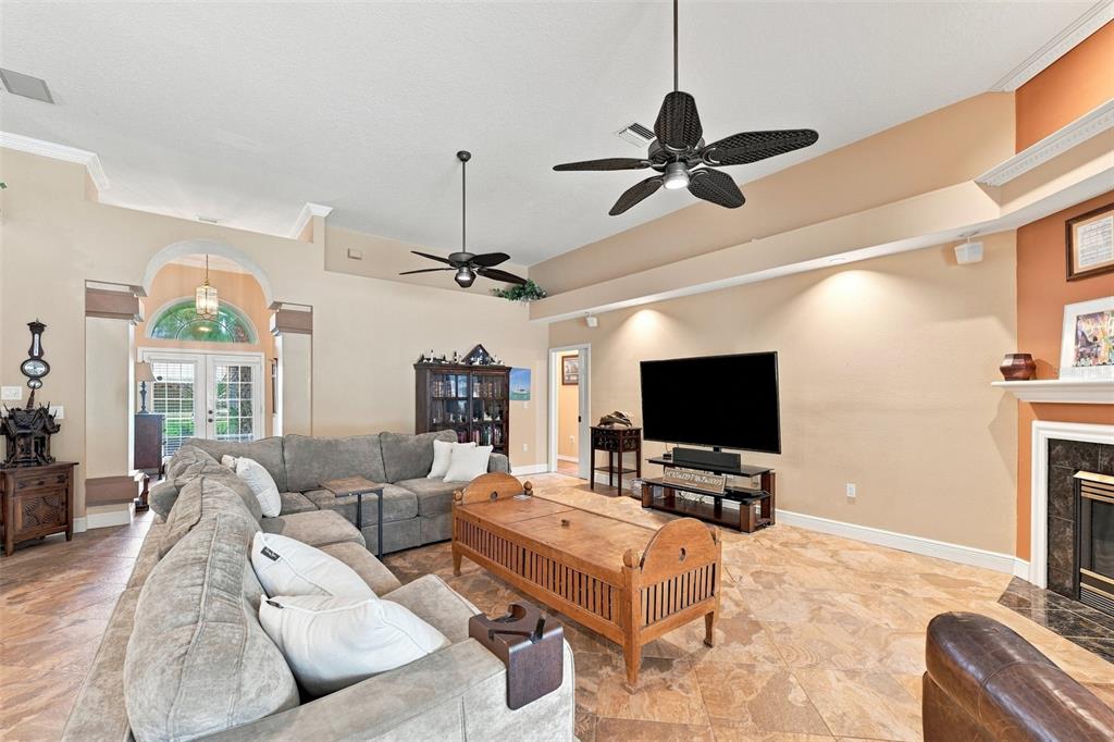 A living room features a sectional sofa, a wooden coffee table, a television, and tile flooring — 18416 AUTUMN LAKE BOULEVARD, HUDSON, FL