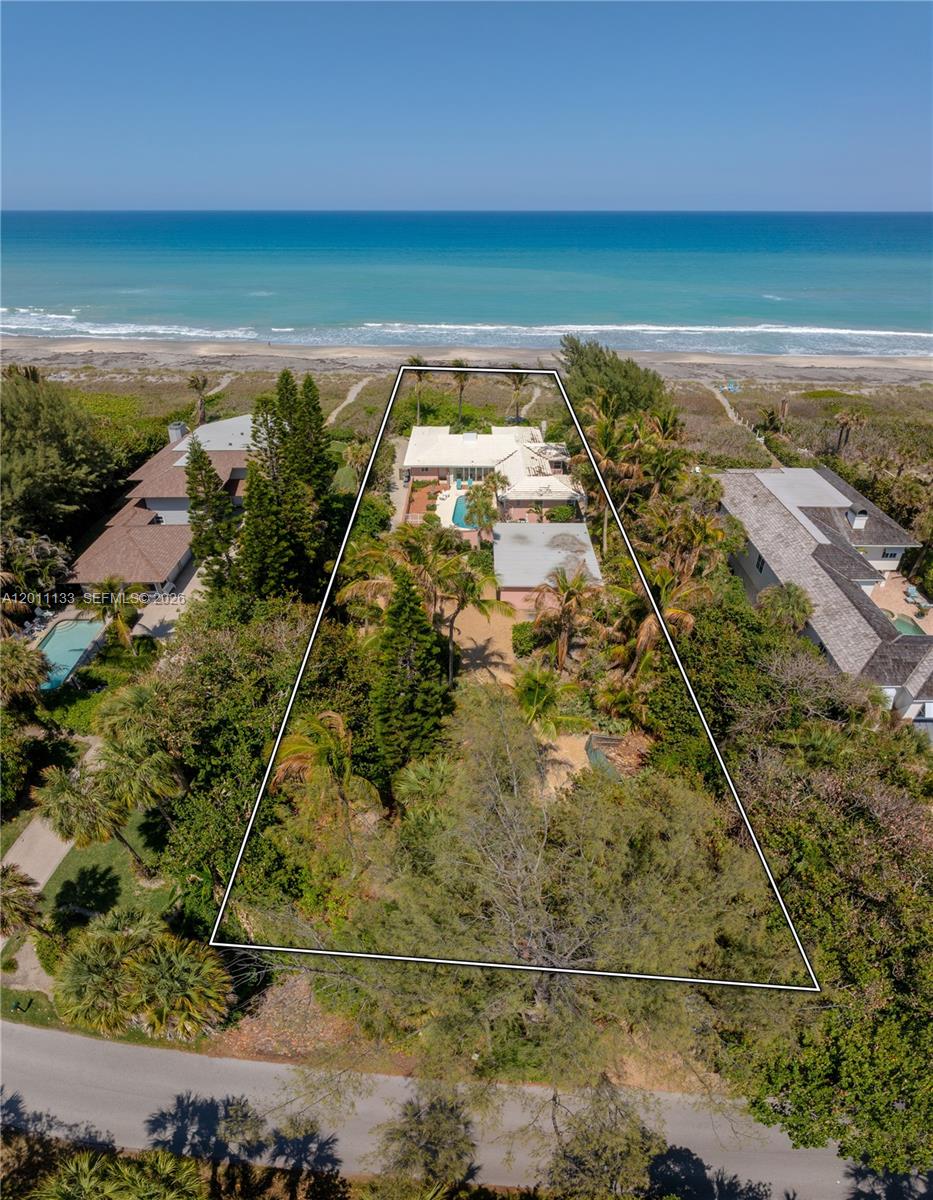 An aerial view shows a beachfront house with a pool on a large, wooded lot — 55 N Beach Rd, Jupiter Island FL 33455, JUPITER ISLAND, FL