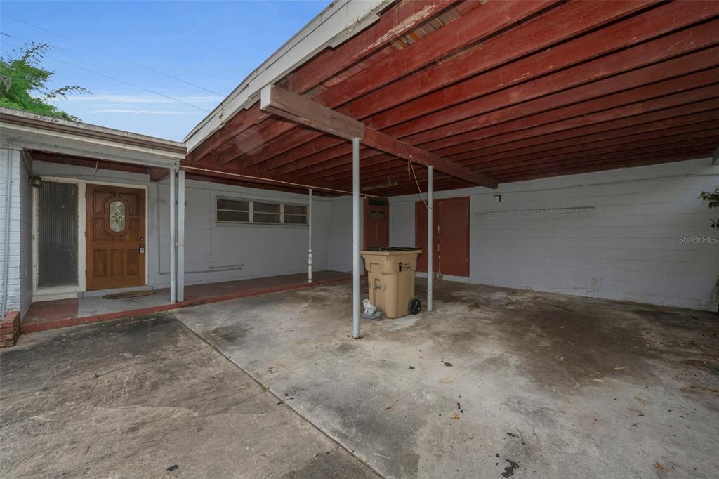 A concrete driveway leads to a covered carport attached to the side of a house — 509 BROXBURN AVENUE, TAMPA, FL