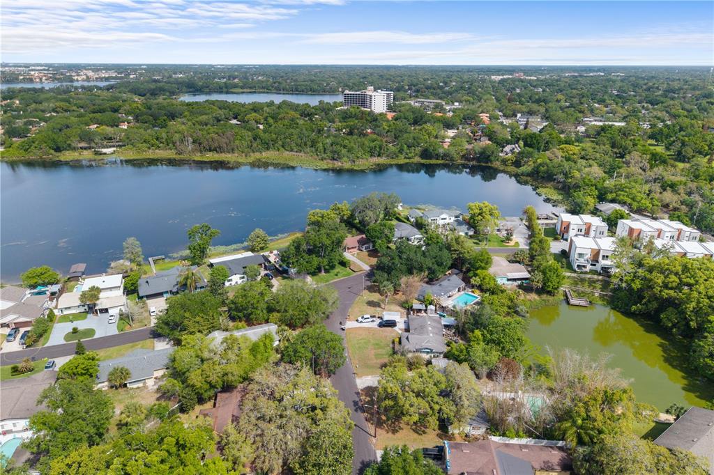An aerial view shows houses situated along a lake with surrounding trees and vegetation — 1881 LAKE SPIER DRIVE, WINTER PARK, FL