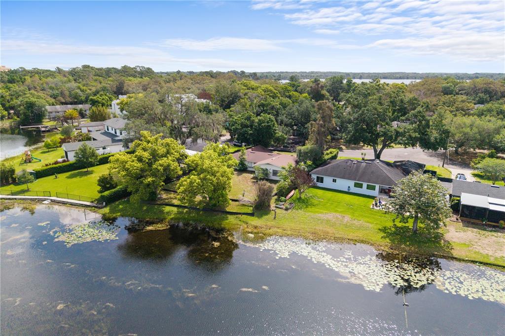 An aerial view shows waterfront houses with large lawns and trees bordering a lake — 1881 LAKE SPIER DRIVE, WINTER PARK, FL