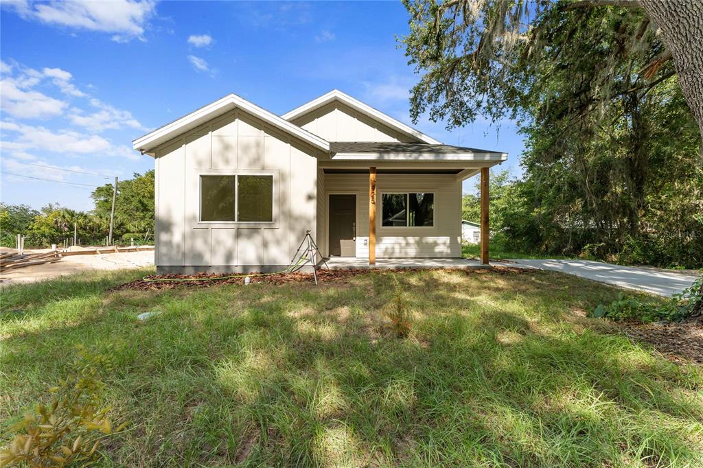 A newly constructed single-story house with light siding and a covered front porch — 925 NE 17TH DRIVE, GAINESVILLE, FL