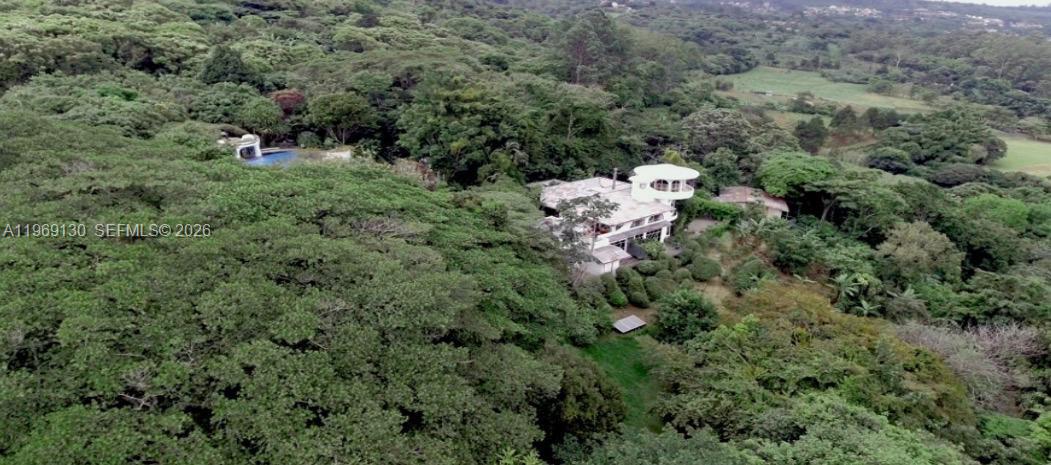 An aerial view shows a white house with a circular tower nestled in dense forest — Santa Barbara de Heredia, Costa Rica, 00000, FL
