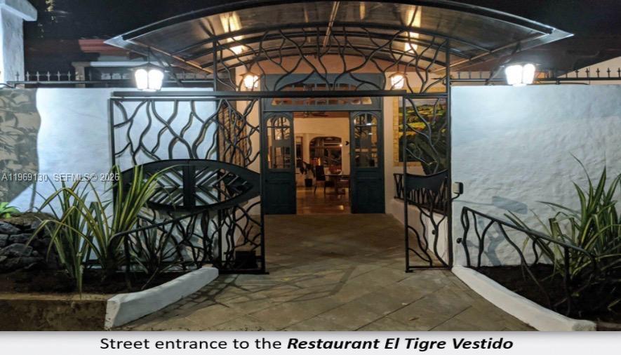 The entrance to Restaurant El Tigre Vestido features a decorative metal gate and arched awning — Santa Barbara de Heredia, Costa Rica, 00000, FL