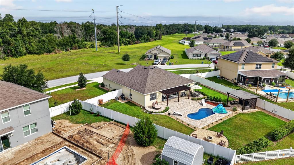 An aerial view shows suburban houses with swimming pools and fenced backyards — 4222 NE 29TH PLACE, OCALA, FL