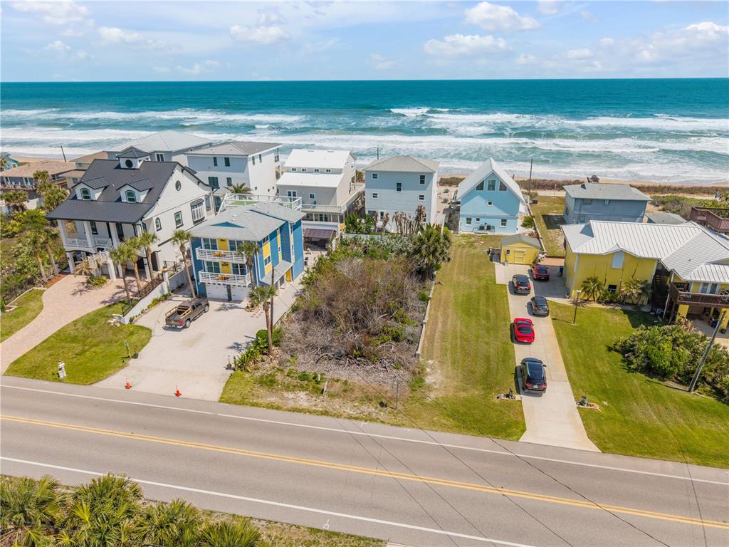 An aerial view shows several beach houses and a vacant lot along a coastal road — TURTLEMOUND ROAD, NEW SMYRNA BEACH, FL