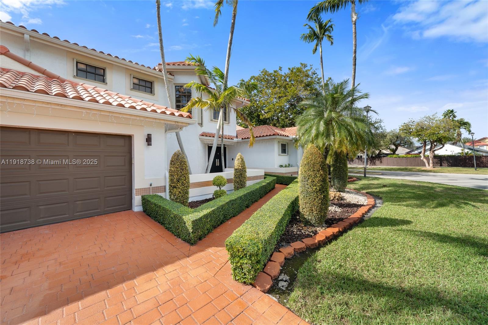 A two-story house features a brown garage, a tiled walkway, and manicured hedges — 5424 SW 154th Pl # 5424, Miami FL 33185, MIAMI, FL