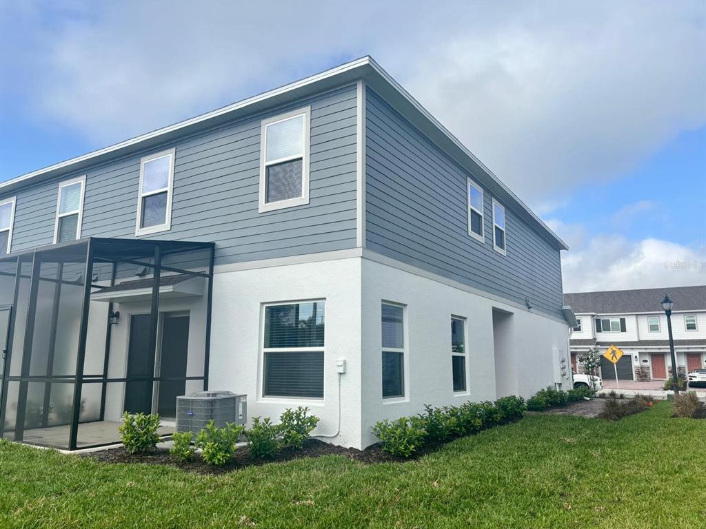 A two-story house with blue horizontal siding, white stucco, and a screened-in back patio — 4616 CAMPSITE, ORLANDO, FL
