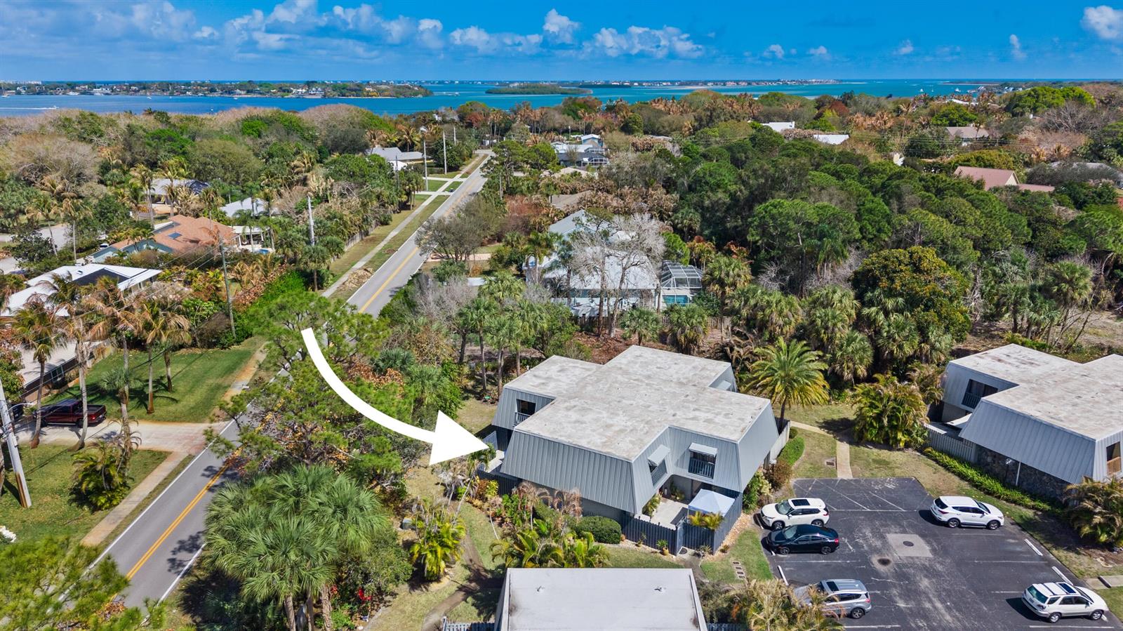 An aerial view shows a multi-story building with a metal roof near a coastal road — 3852 SE Jefferson Street, Stuart FL 34997, STUART, FL