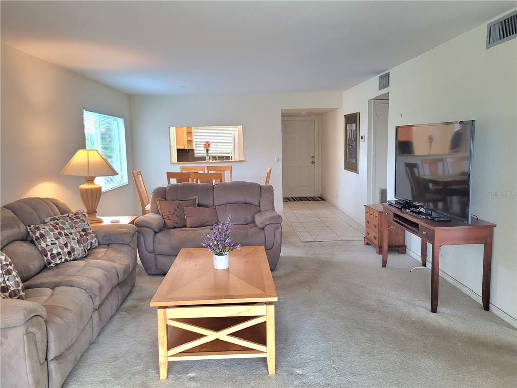 A living room with beige carpet, two brown sofas, a wooden coffee table, and television — 9861 Sunrise Lakes  Blvd SUNRISE LAKES BOULEVARD UNIT 310, SUNRISE, FL