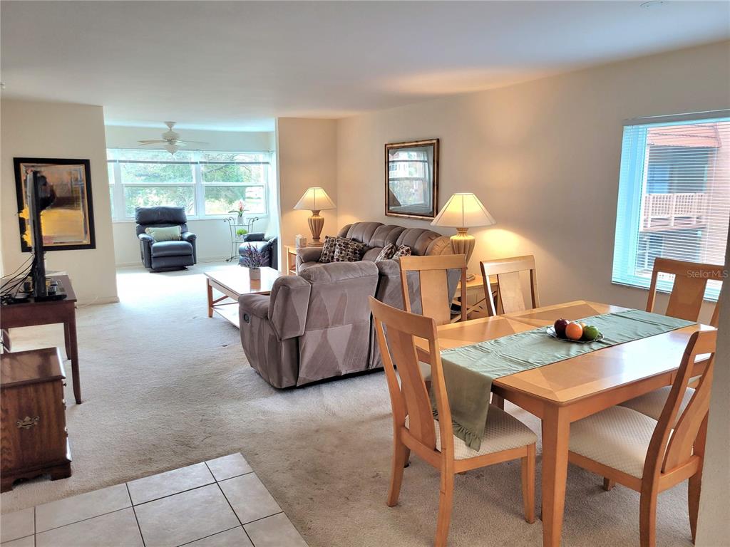 A dining area and living room feature carpeted floors, a sofa, and a wooden table — 9861 Sunrise Lakes  Blvd SUNRISE LAKES BOULEVARD UNIT 310, SUNRISE, FL