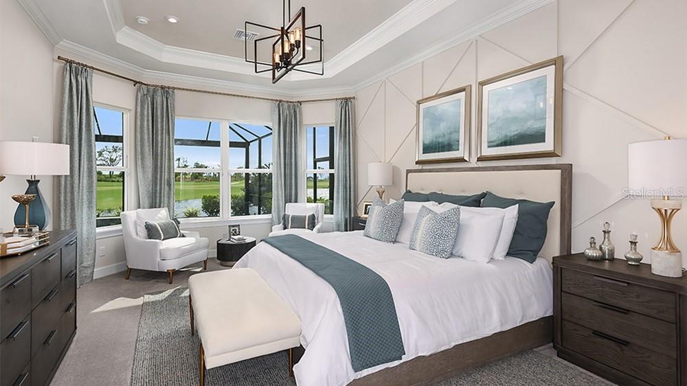 A bedroom features a king bed, a tray ceiling with a chandelier, and large windows — 14623 CONTENTA LOOP, BRADENTON, FL