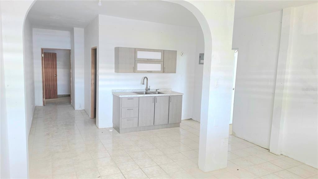 A kitchen area features light wood cabinets, a stainless steel sink, and white tiled floors — Bloque AB  5 CALLE JULIO ANDINO, SAN JUAN, PR