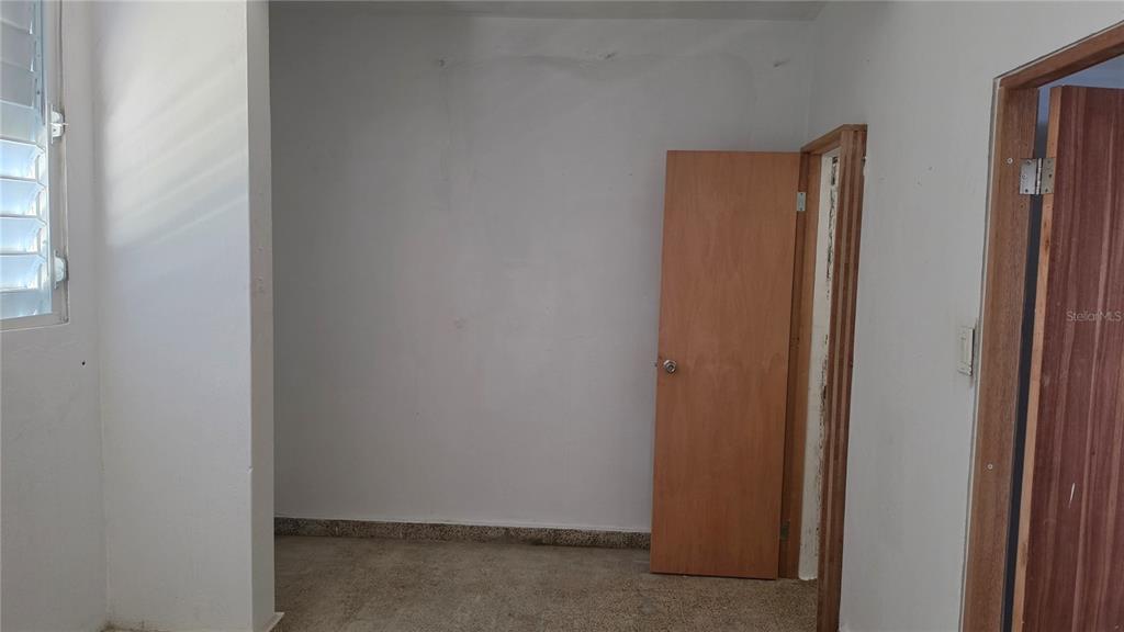 An interior room with white walls, a wooden door, and a concrete floor — Bloque AB  5 CALLE JULIO ANDINO, SAN JUAN, PR