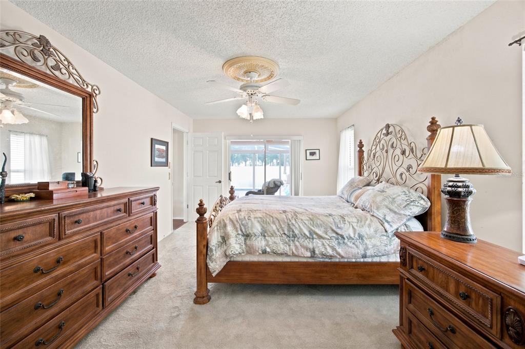 A living room features a beige sofa, a red patterned rug, and a bay window — 2292 WHISPER WALK DRIVE, SPRING HILL, FL