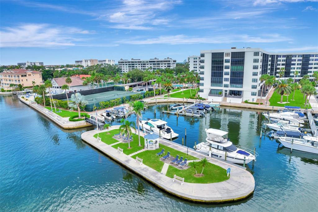 An aerial view of a marina with docked boats, a gazebo, and surrounding residential buildings — 5855 MIDNIGHT PASS ROAD UNIT 314, SARASOTA, FL