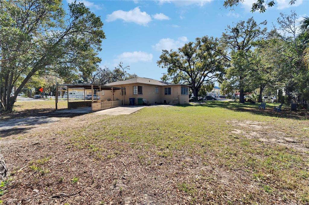 The exterior of a tan, single-story house features a carport and a large, grassy yard — 2606 N BOULEVARD, TAMPA, FL