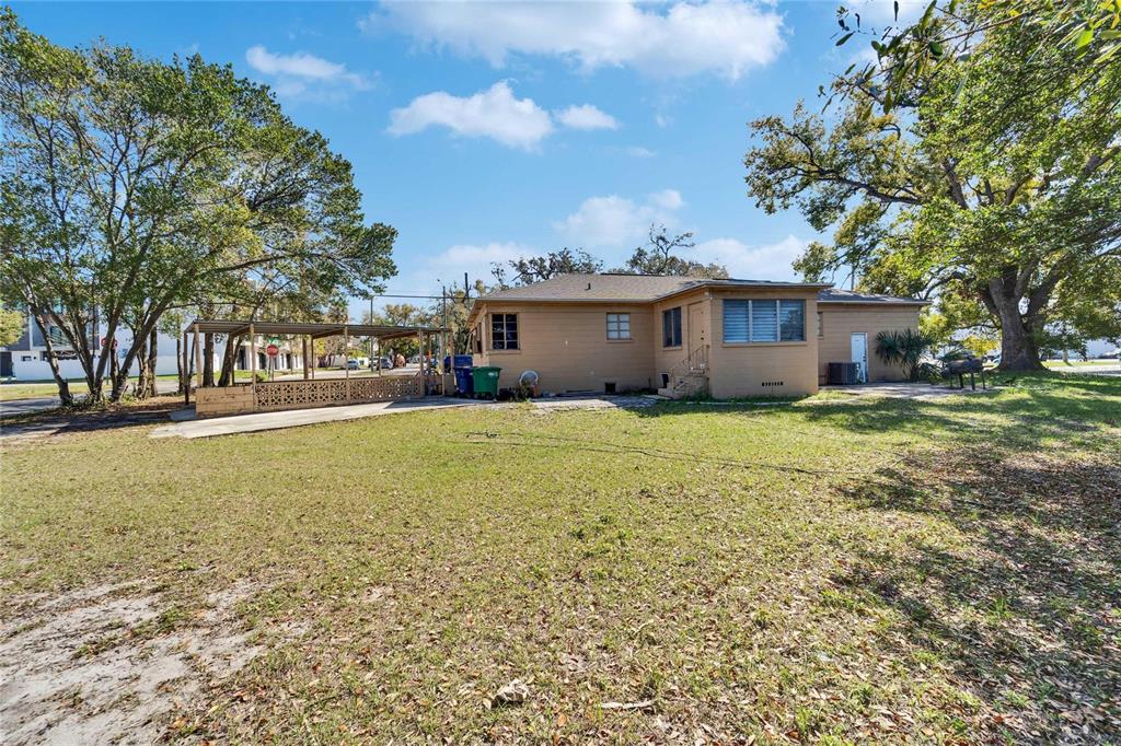 The exterior of a tan, single-story house with a carport and a large grassy yard — 2606 N BOULEVARD, TAMPA, FL