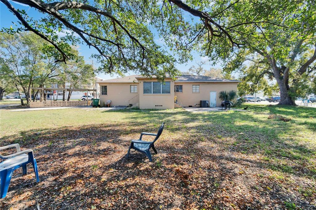 The exterior of a single-story house with a large backyard and mature trees — 2606 N BOULEVARD, TAMPA, FL