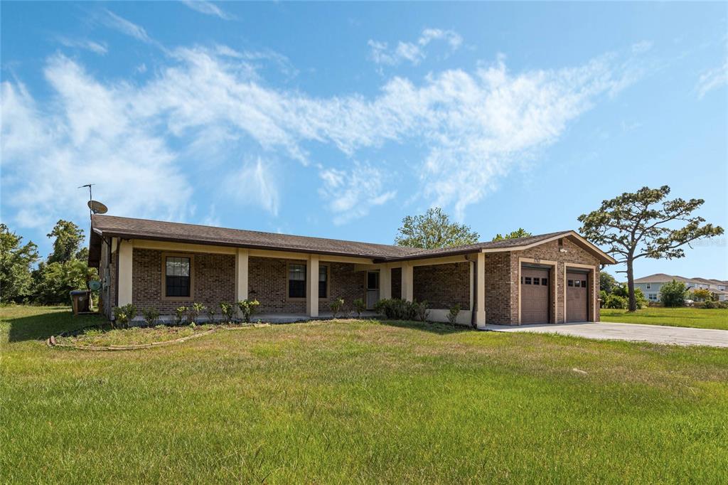A single-story brick house with a covered porch and an attached two-car garage — 5760 LEON TYSON ROAD, ST CLOUD, FL