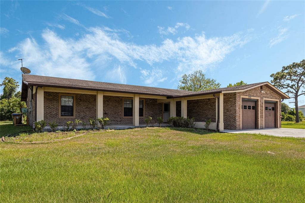 A single-story brick house features a covered front porch and an attached two-car garage — 5760 LEON TYSON ROAD, ST CLOUD, FL