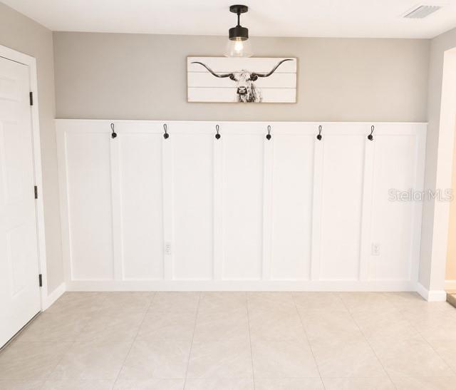 A room with white board and batten wall paneling, coat hooks, and a longhorn print — 4208 DOVETAIL LANE, PALMETTO, FL