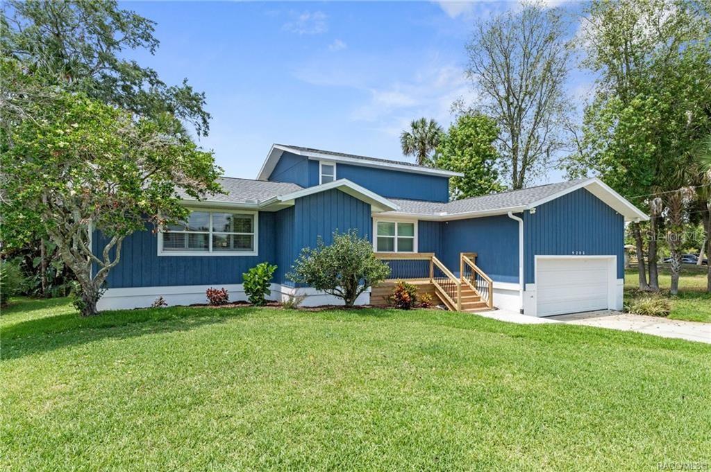 A blue, single-story house with a white garage and a wooden front deck — 9205 W HARBOR ISLE COURT, CRYSTAL RIVER, FL
