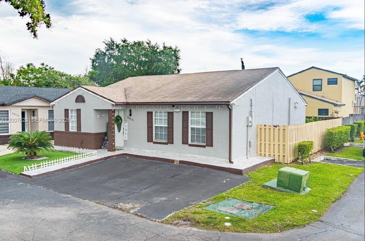 A single-story house with a gray stucco exterior, brown shutters, and an asphalt driveway — 8419 NW 193rd Ln, Hialeah FL 33015, HIALEAH, FL