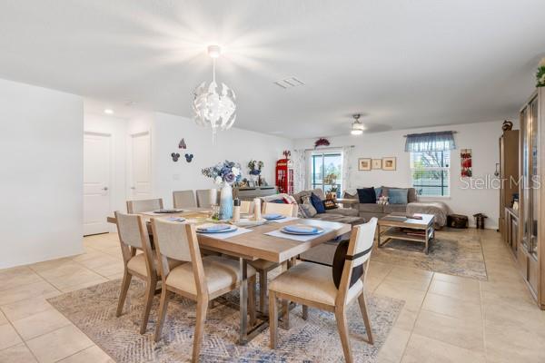 A dining area with a wooden table and chairs sits in an open-concept living space — 4382 FINCH LANE, KISSIMMEE, FL
