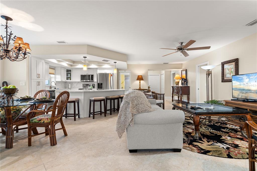 An open-concept kitchen and living area features tile flooring, white cabinetry, and a dining set — 101 N MARION COURT UNIT 235, PUNTA GORDA, FL