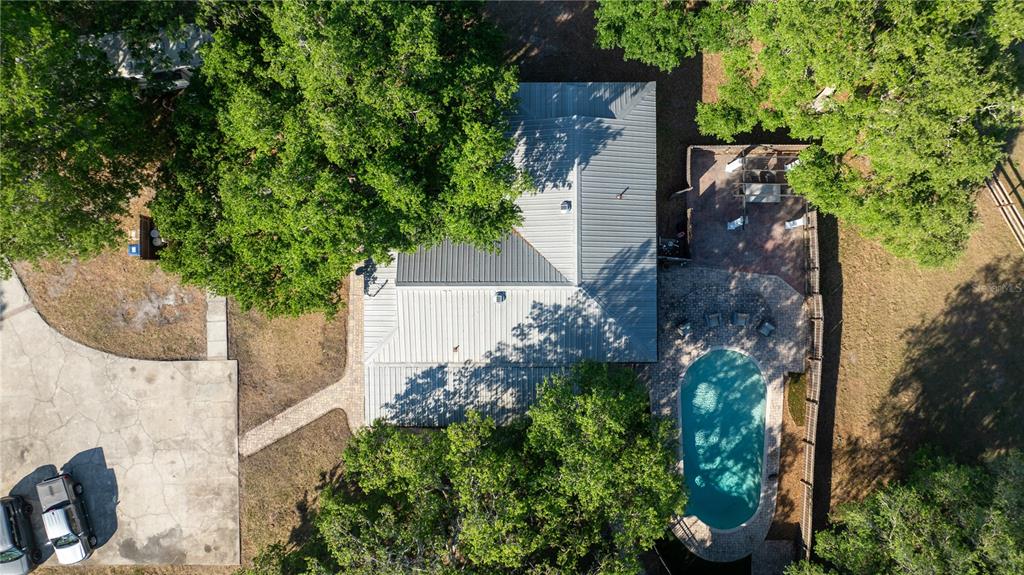 An aerial view shows a house with a metal roof, a pool, and a driveway — 5160 HAYWOOD RUFFIN ROAD, ST CLOUD, FL