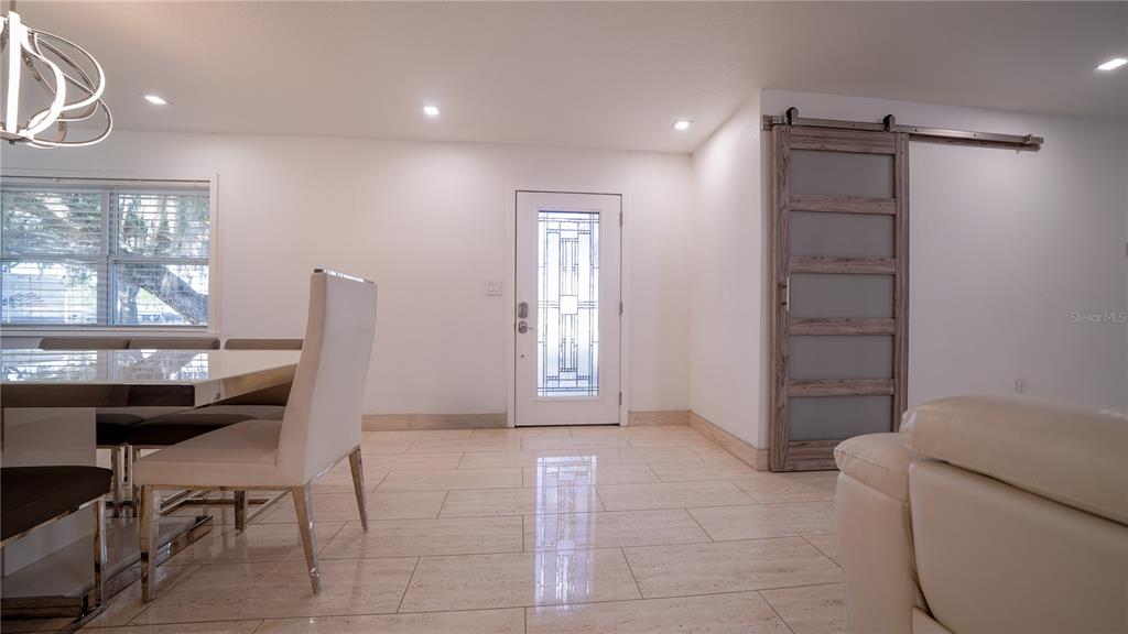 A spacious open-concept living and dining area features white tile flooring and a sectional sofa — 5160 HAYWOOD RUFFIN ROAD, ST CLOUD, FL
