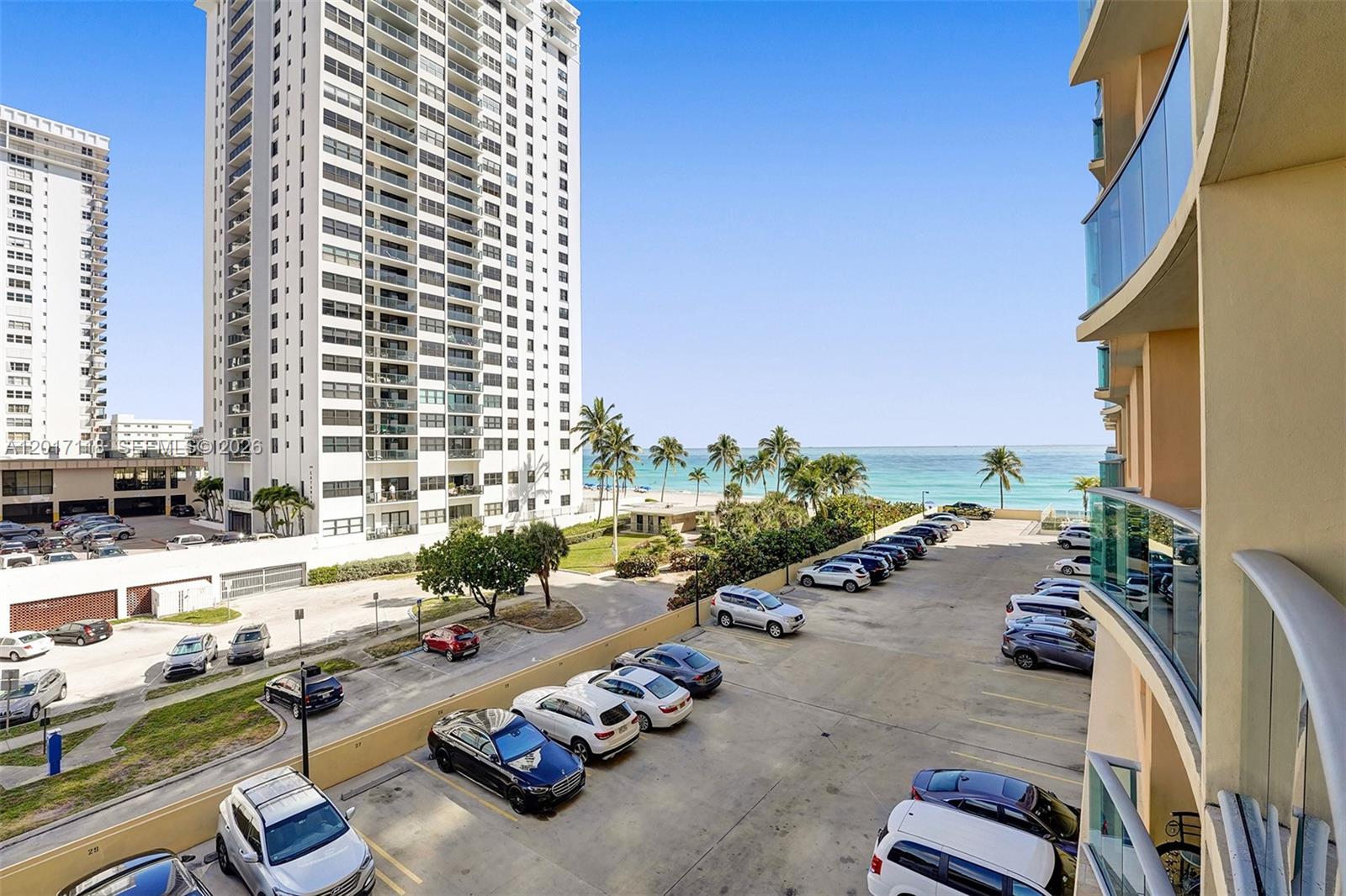 An elevated view shows a parking lot, a tall residential building, and the ocean beyond — 2501 S Ocean Dr, Hollywood FL 33019, HOLLYWOOD, FL