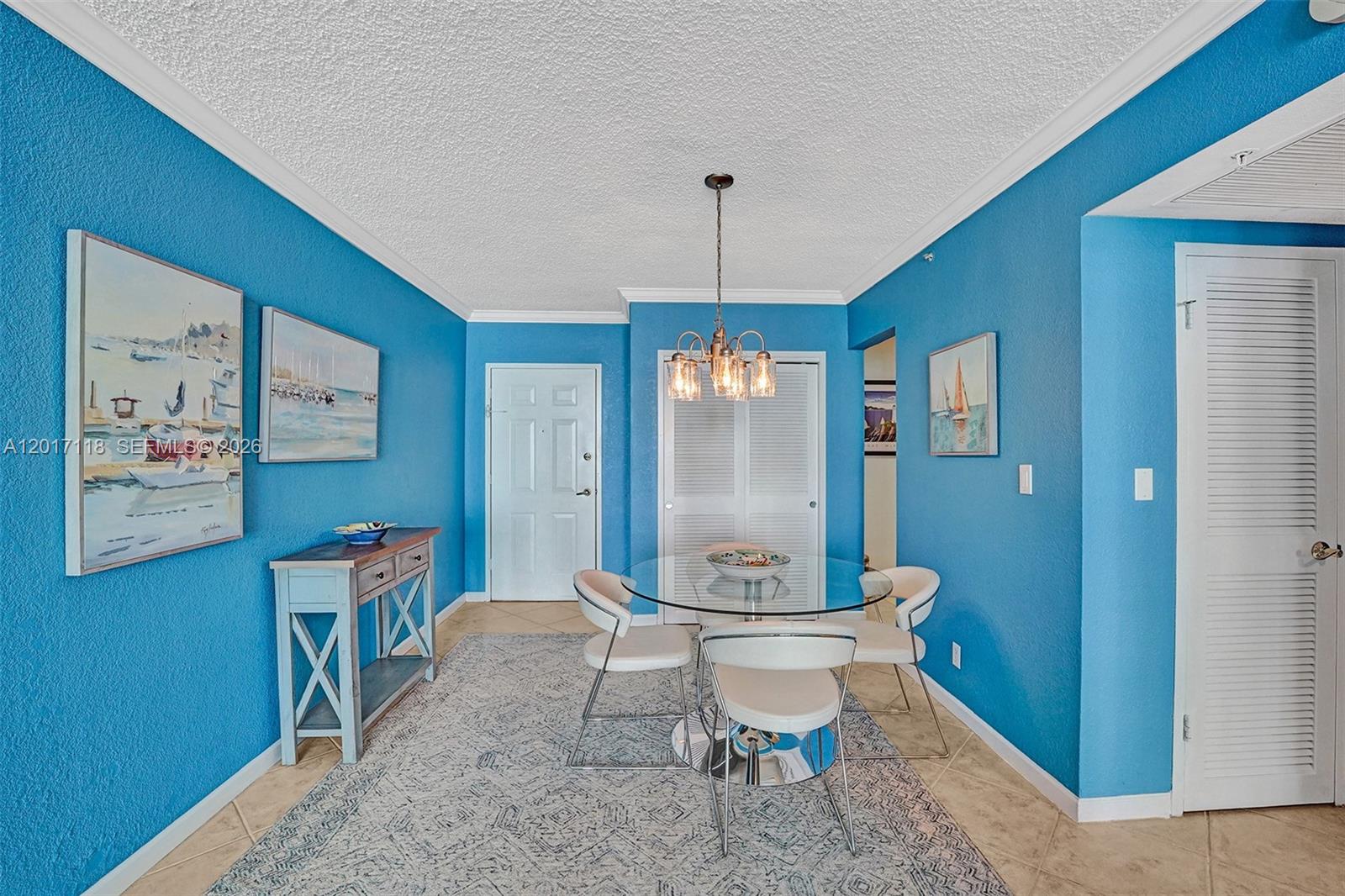 A dining area features blue walls, a glass-topped table with four chairs, and a chandelier — 2501 S Ocean Dr, Hollywood FL 33019, HOLLYWOOD, FL