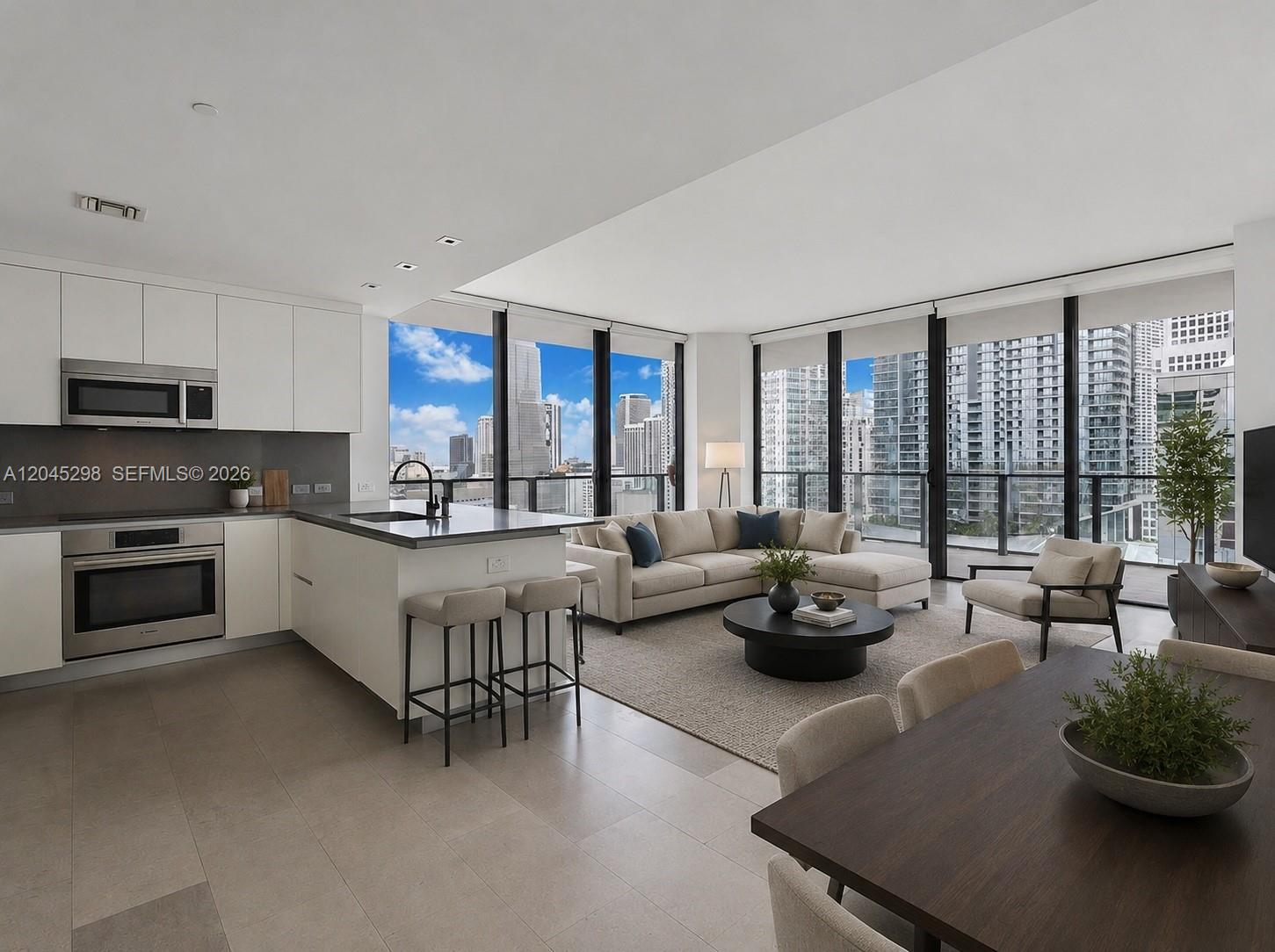 A modern open-concept living area features a kitchen with white cabinets and floor-to-ceiling windows — 88 SW 7th St # 1511, Miami FL 33130, MIAMI, FL