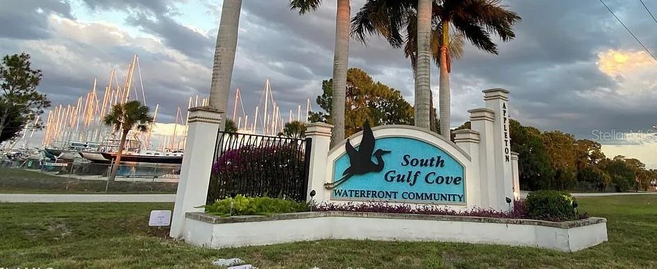 A sign for the South Gulf Cove waterfront community stands before a marina with sailboats — 9604 ARNAZ CIRCLE, PORT CHARLOTTE, FL