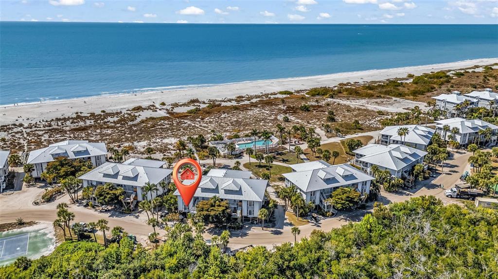An aerial view shows a coastal condominium complex with a pool near the beach — 7454 PALM ISLAND DRIVE UNIT 3311, PLACIDA, FL