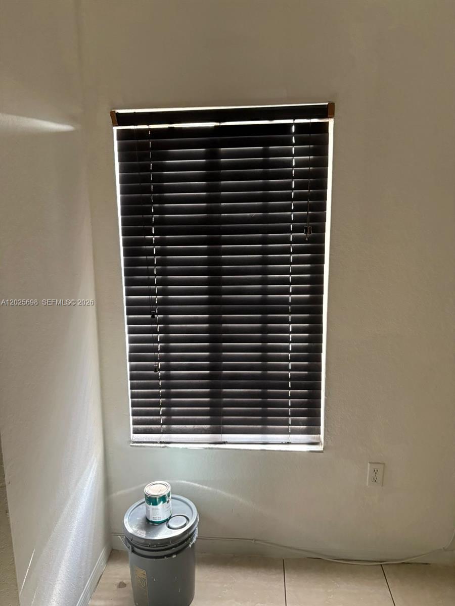 A window with dark horizontal blinds is centered on a plain wall above a bucket — 117 SE 3rd Ave # 7, Hallandale Beach FL 33009, HALLANDALE BEACH, FL