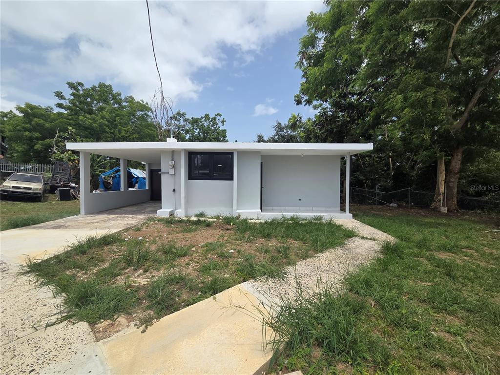 A single-story house with a flat roof, a carport, and a concrete walkway — Colinas de Vista Alegre COLINAS DE VISTA ALEGRE, BAYAMON, PR