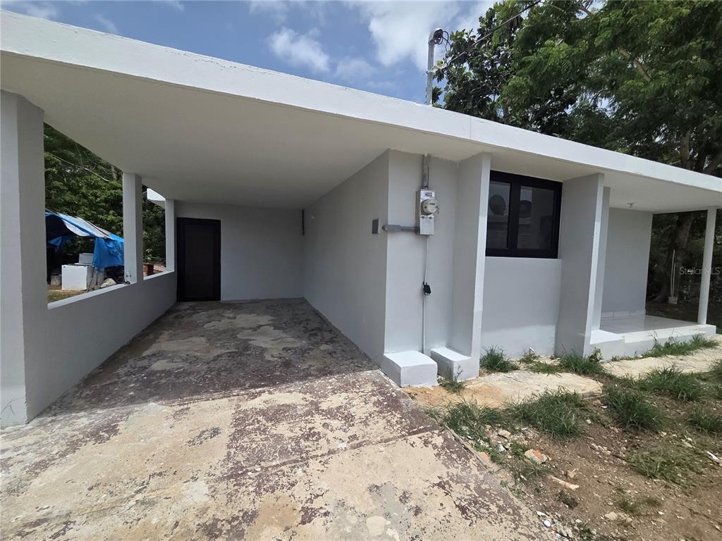 A gray exterior house with a covered carport and a concrete driveway — Colinas de Vista Alegre COLINAS DE VISTA ALEGRE, BAYAMON, PR