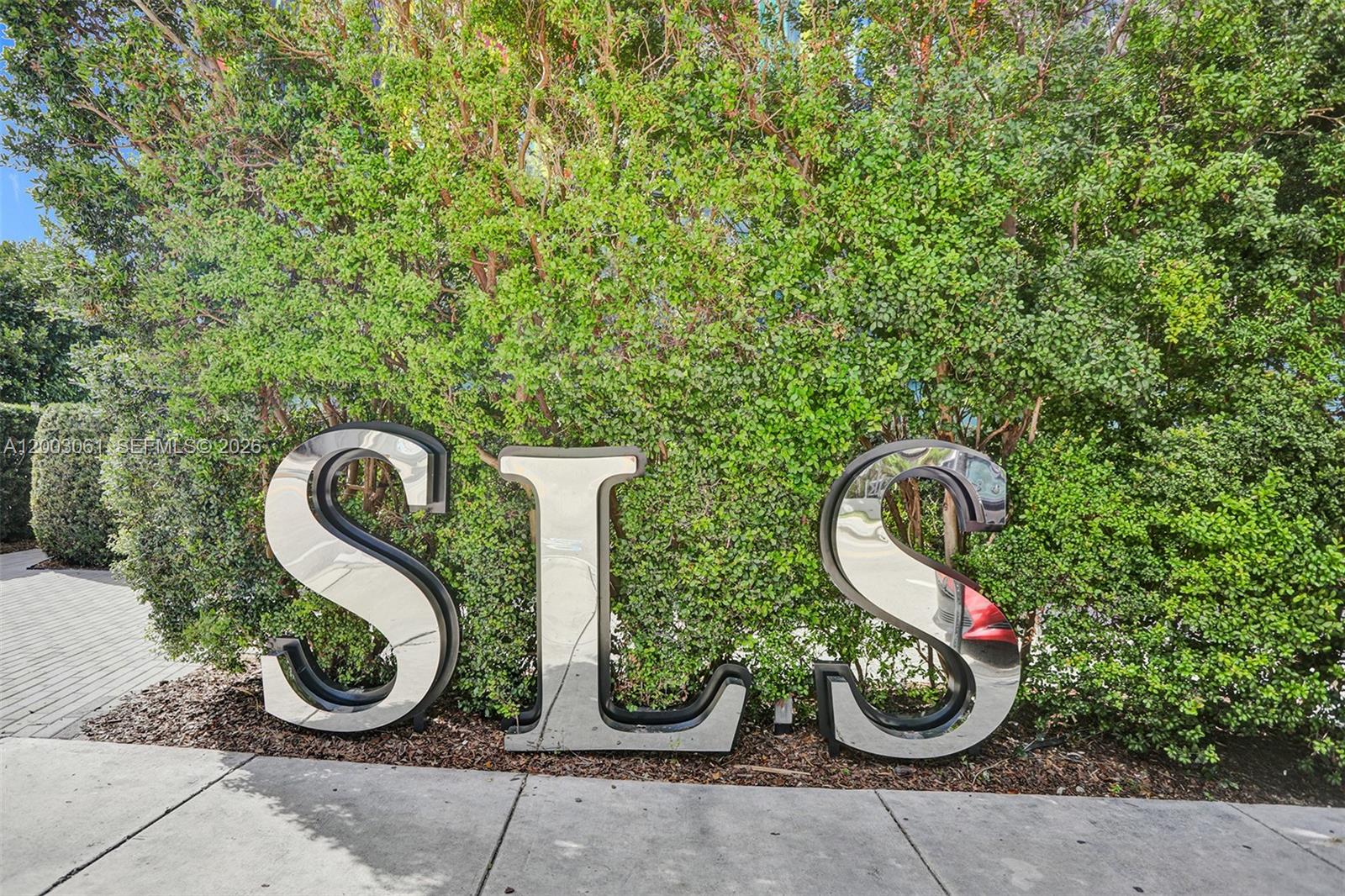 A low-angle exterior view of the SLS Brickell hotel featuring a colorful striped facade — 1300 S Miami Ave # 3111, Miami FL 33130, MIAMI, FL